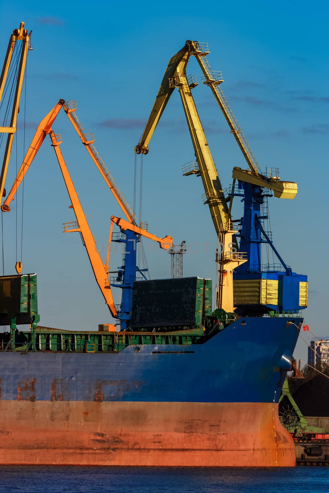 Blue cargo ship loading in the port of Riga, Europe