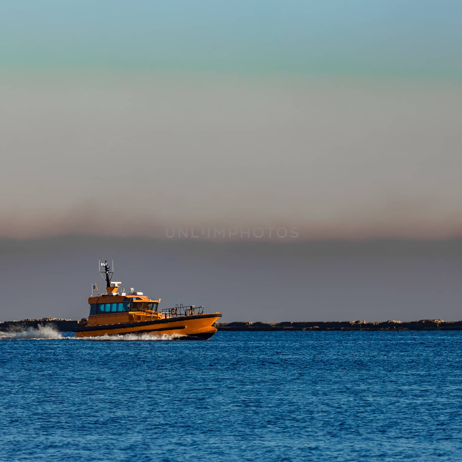 Orange pilot ship sailing from the Baltic sea in Latvia