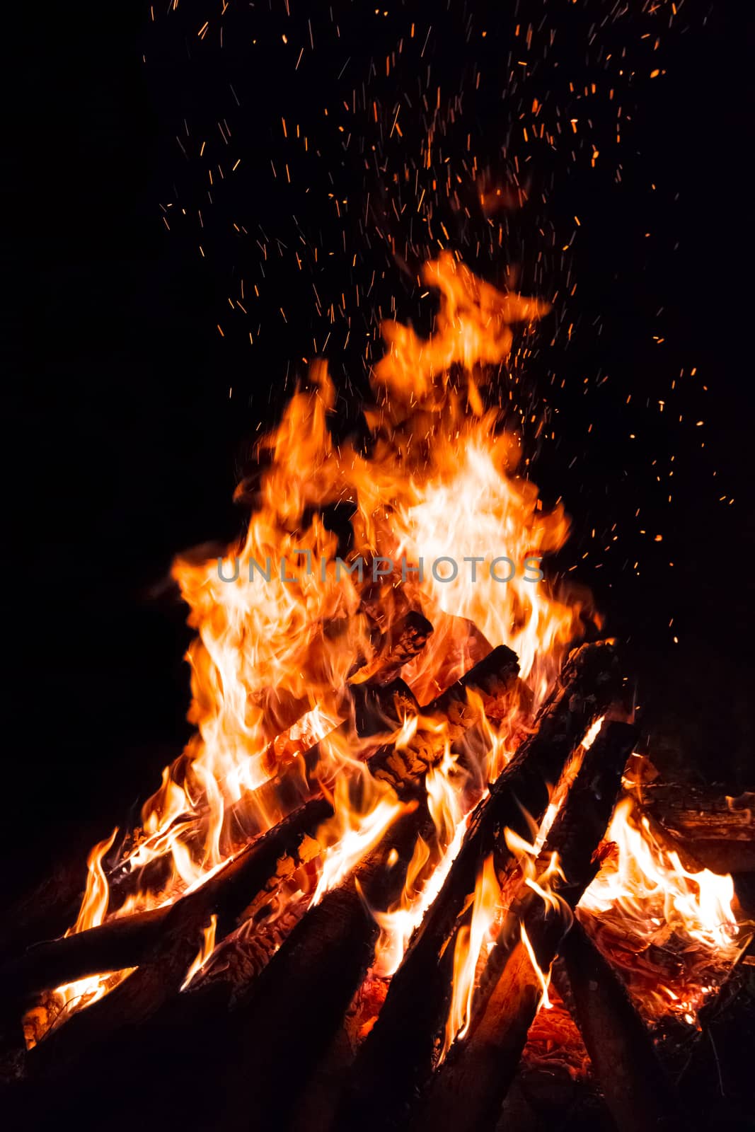 Campfire with flying sparks isolated on black background