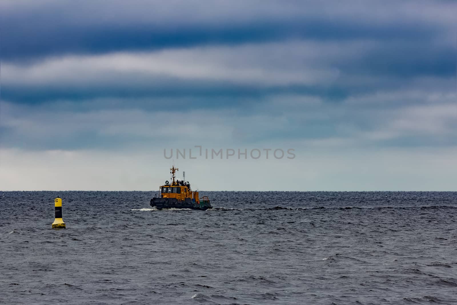 Small orange tug ship moving from the Baltic sea