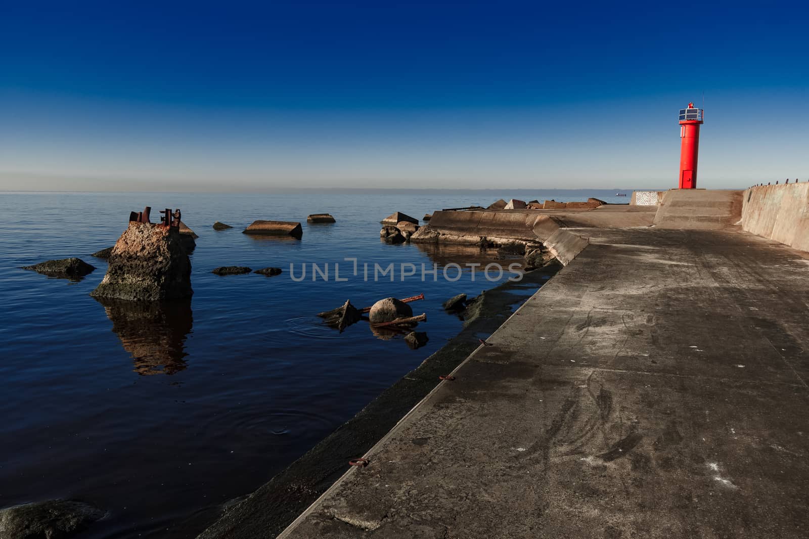 Red lighthouse on breakwater dam by sengnsp