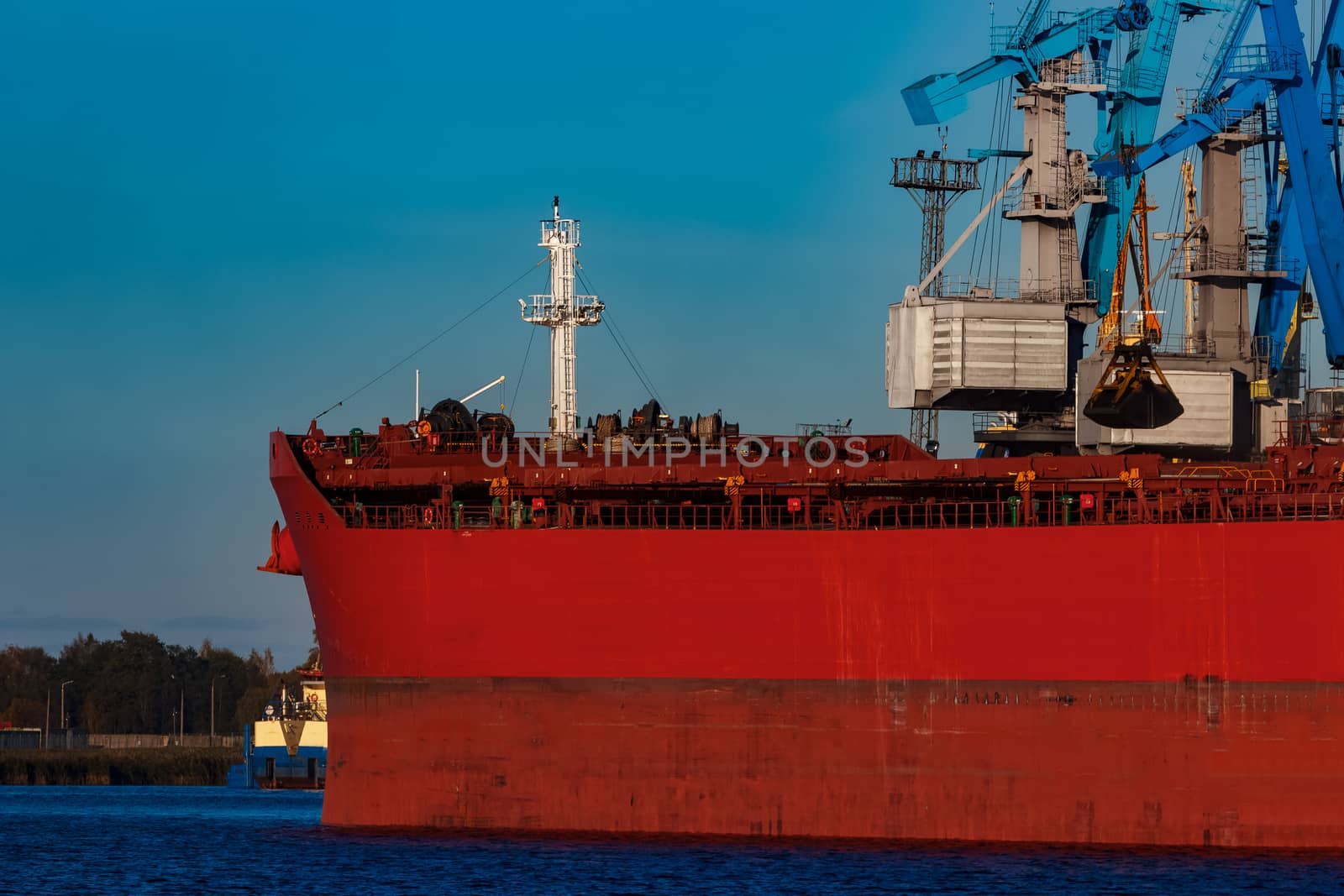 Red cargo ship loading in the port of Riga, Europe