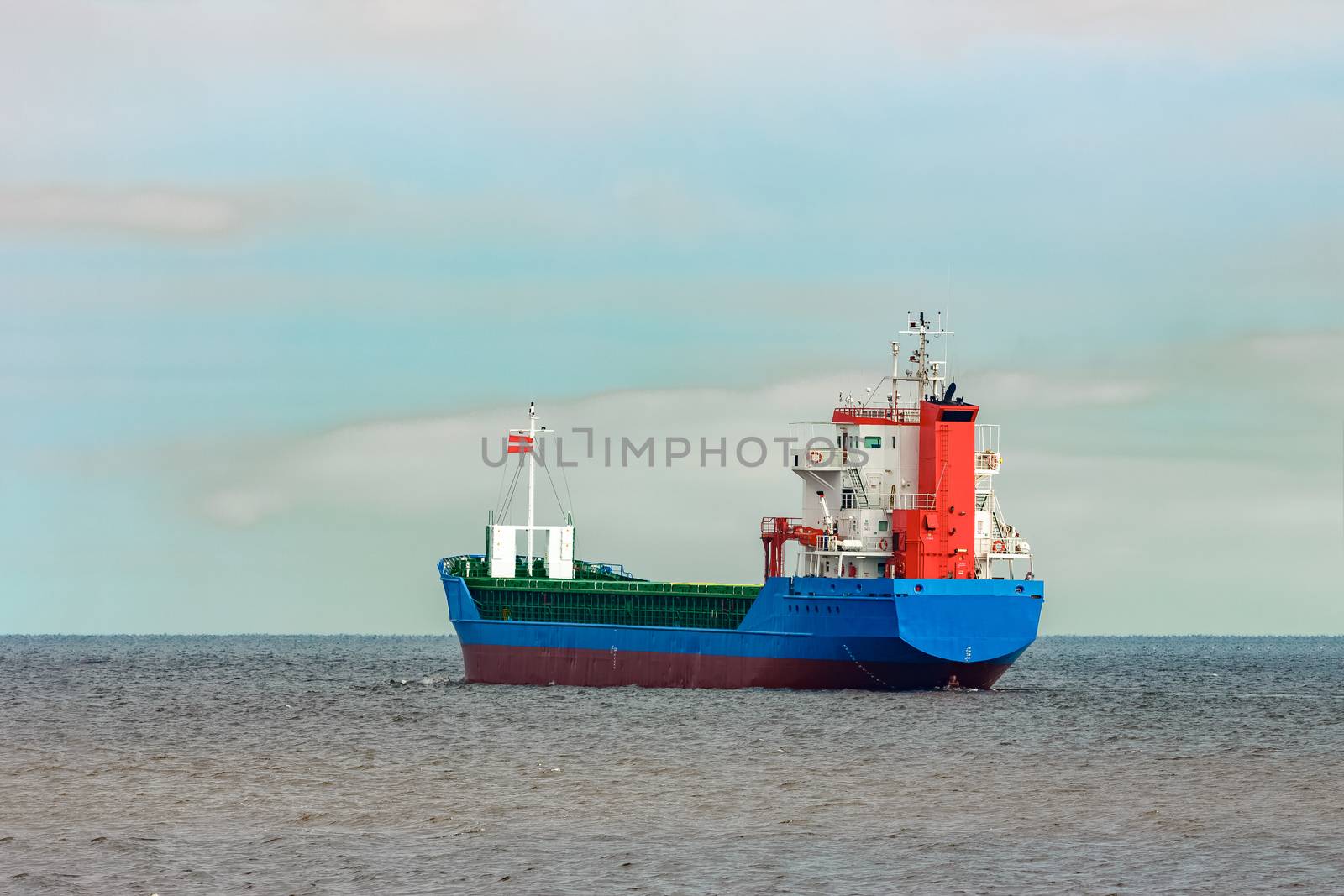 Blue cargo ship entering the Baltic sea. Riga, Europe