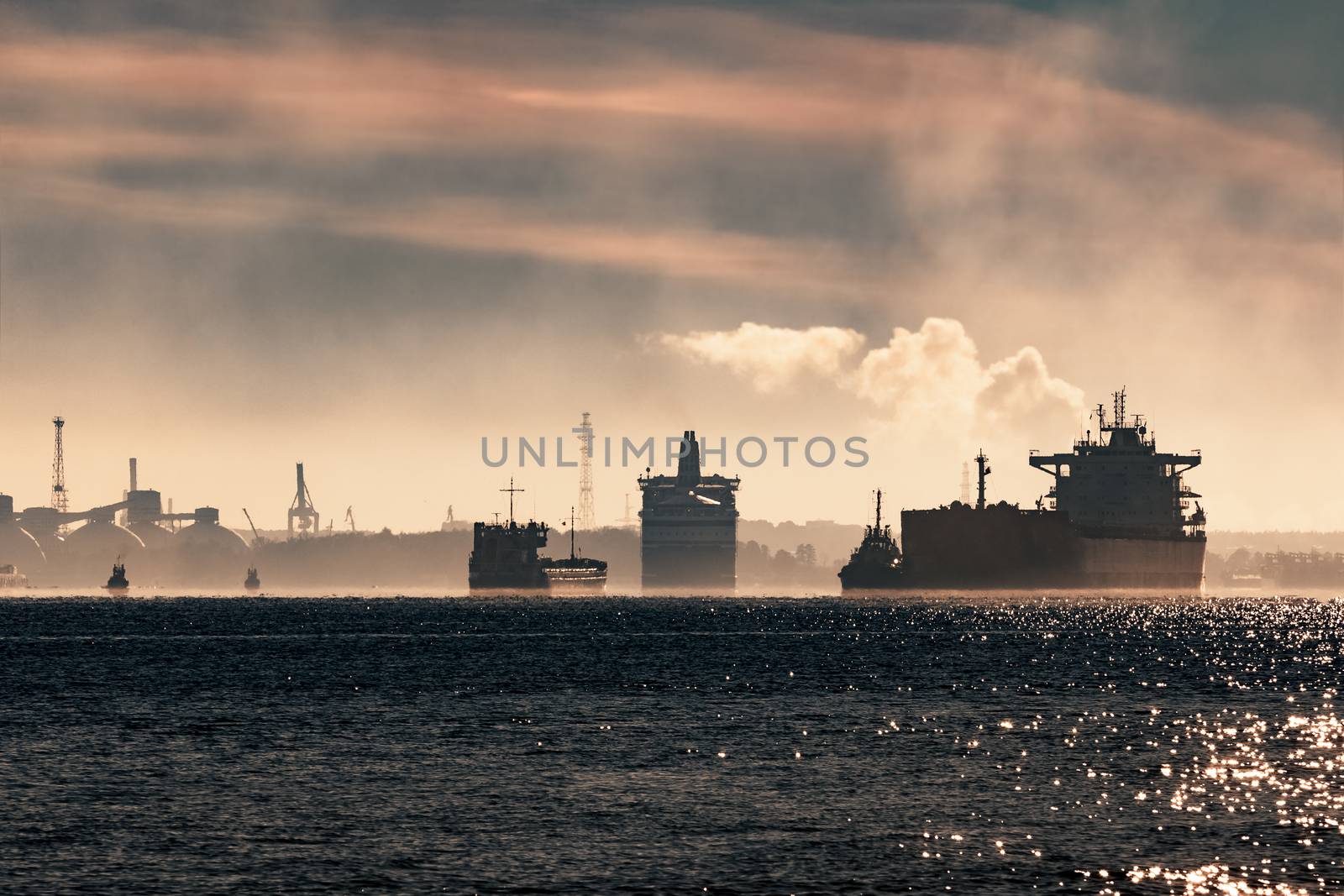 Cargo ship silhouette entering a port of Riga at the morning
