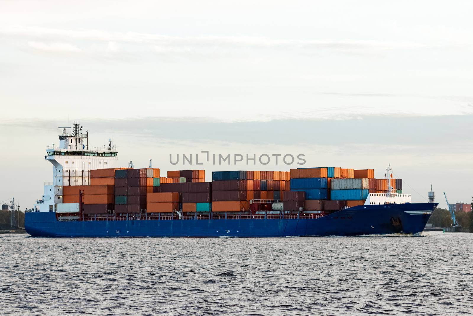 Blue container ship moving to Baltic sea. Riga, Latvia