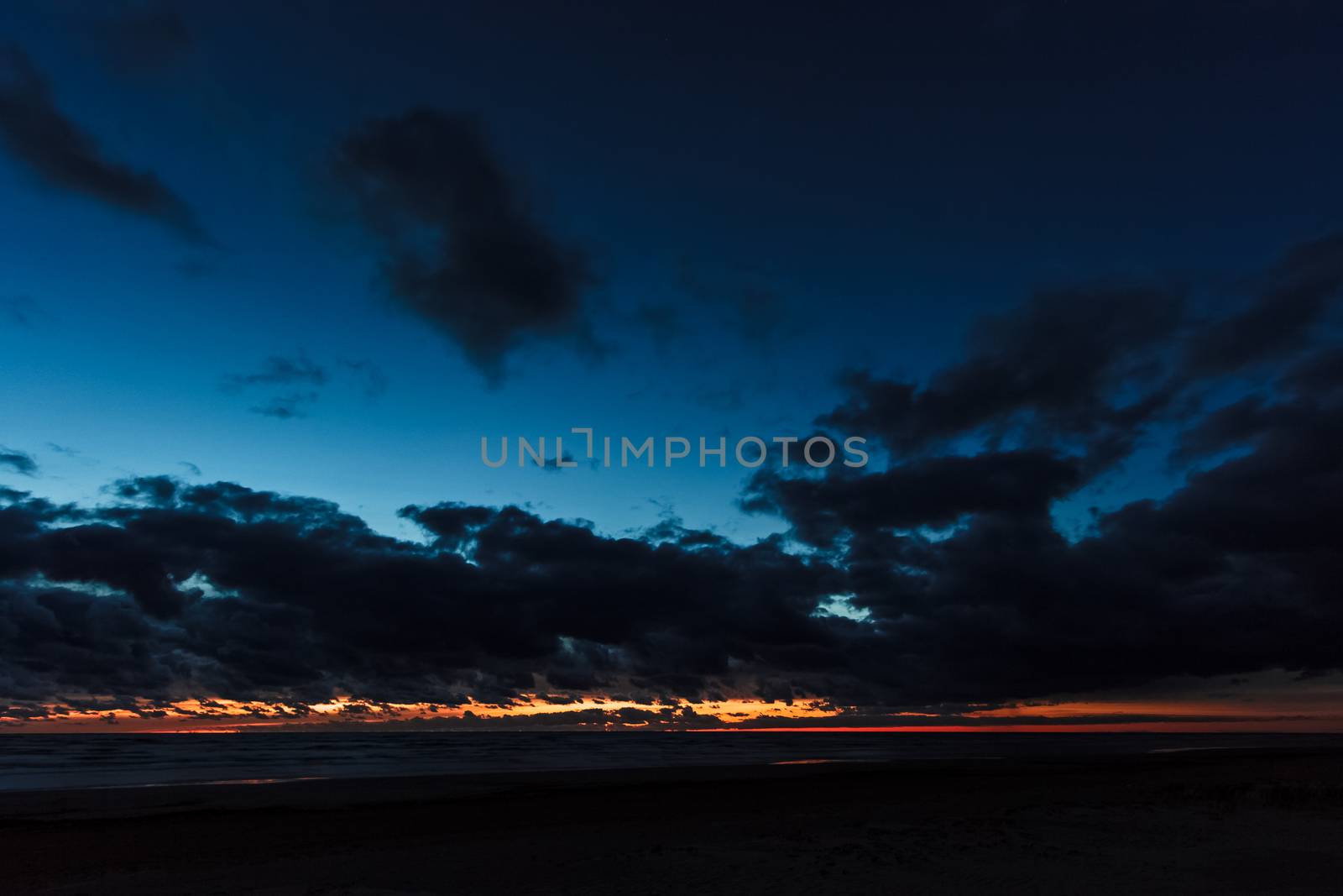 Dark blue cloudy sky over the Baltic sea at night