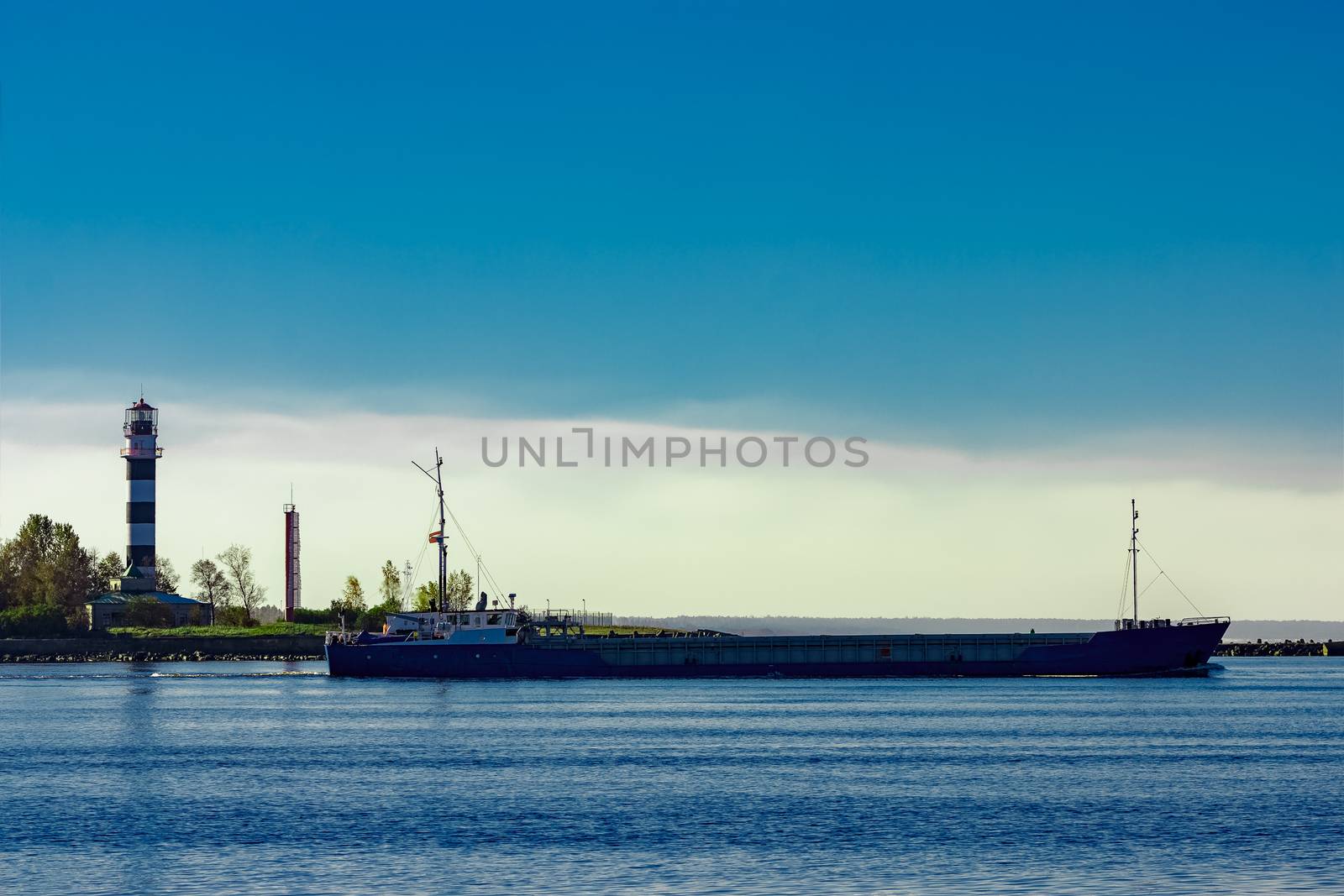 Blue cargo ship leaving Riga and entering Baltic sea