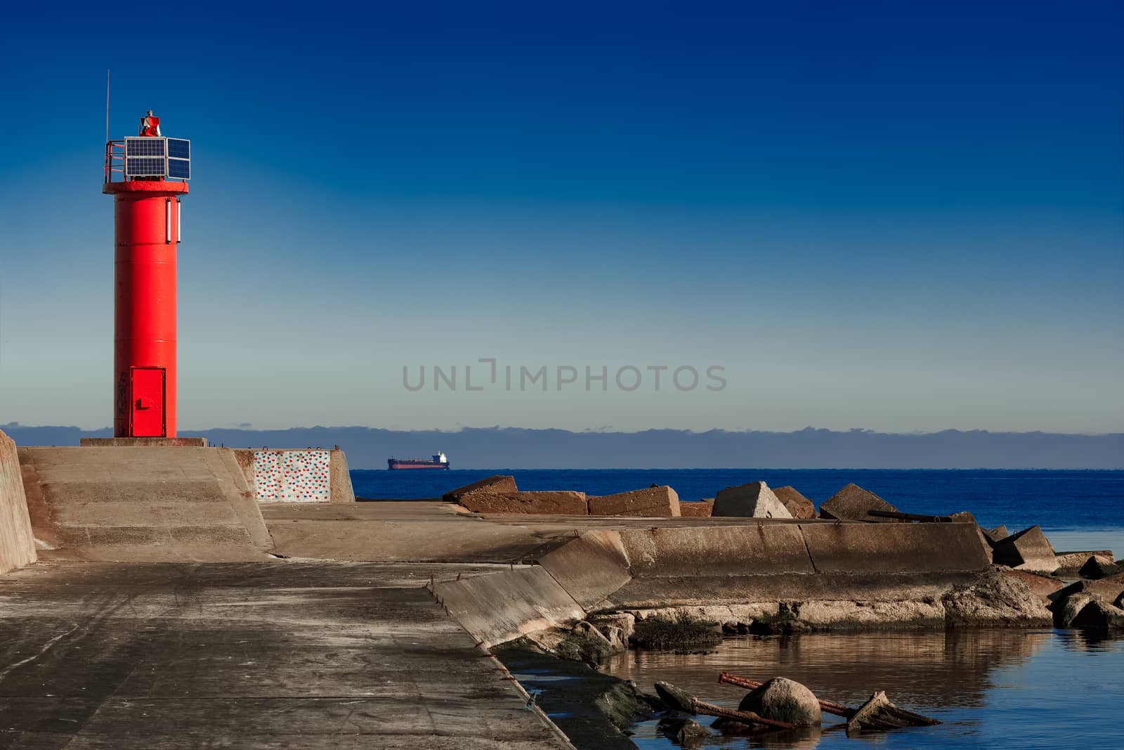 Red lighthouse on breakwater dam by sengnsp