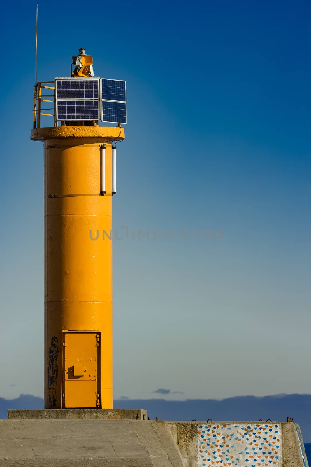 Yellow lighthouse on breakwater dam in Riga, Europe