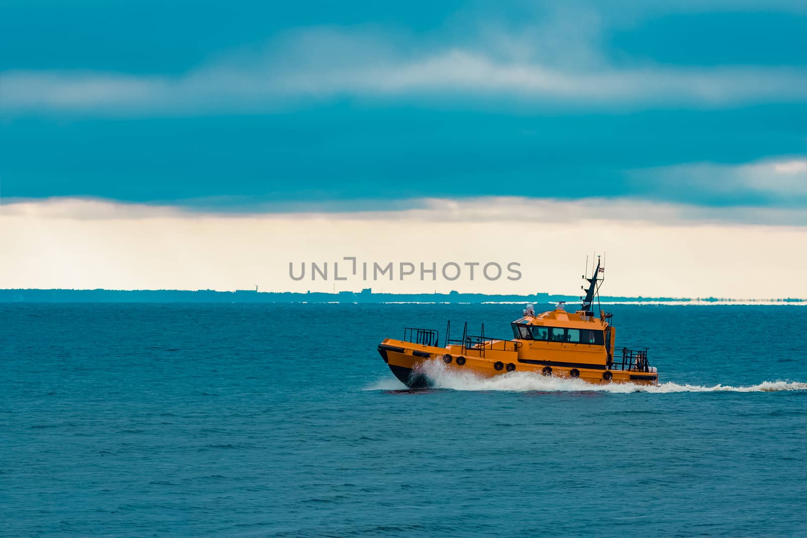 Orange pilot ship moving fast in Baltic sea. Europe