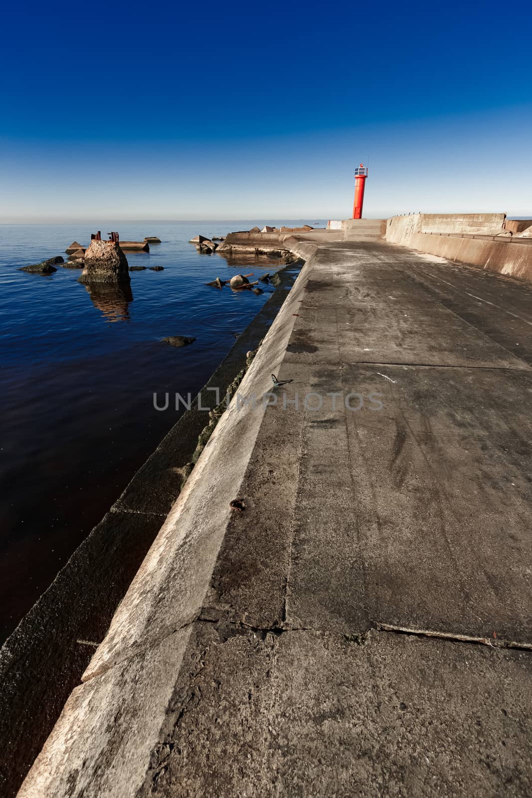 Red lighthouse on breakwater dam by sengnsp