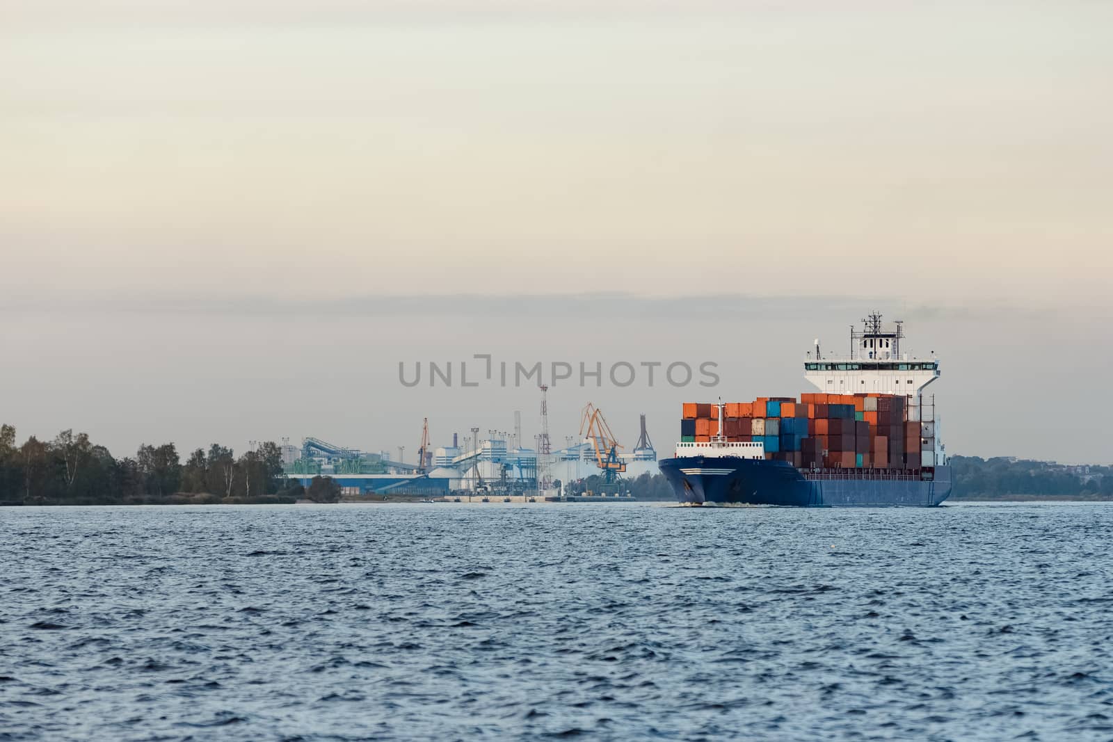 Blue container ship moving to Baltic sea. Riga, Latvia