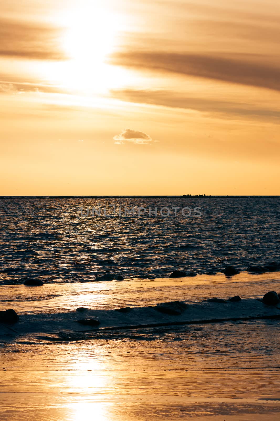 Vertical view of golden sunset at Baltic sea shore