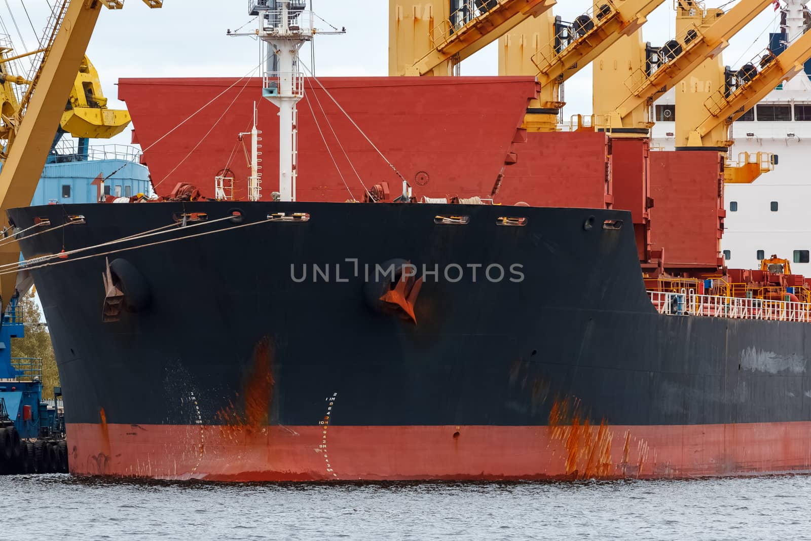 Black cargo ship loading in the port of Riga, Europe