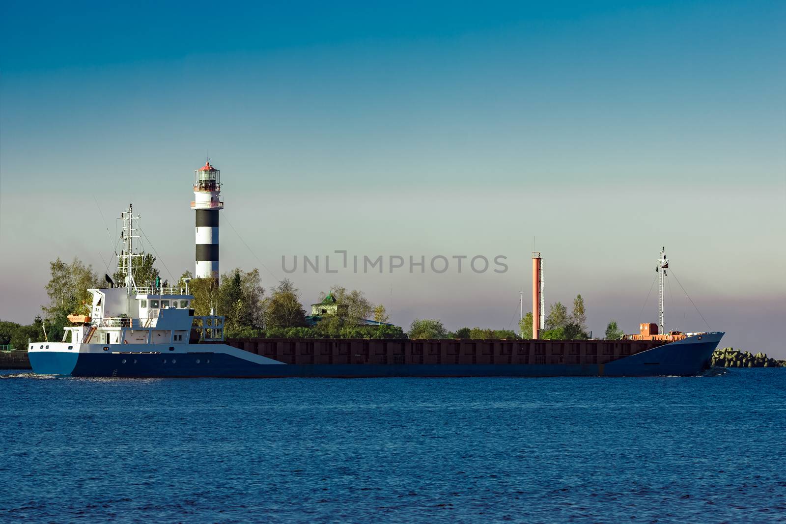 Blue cargo ship leaving Riga and entering Baltic sea