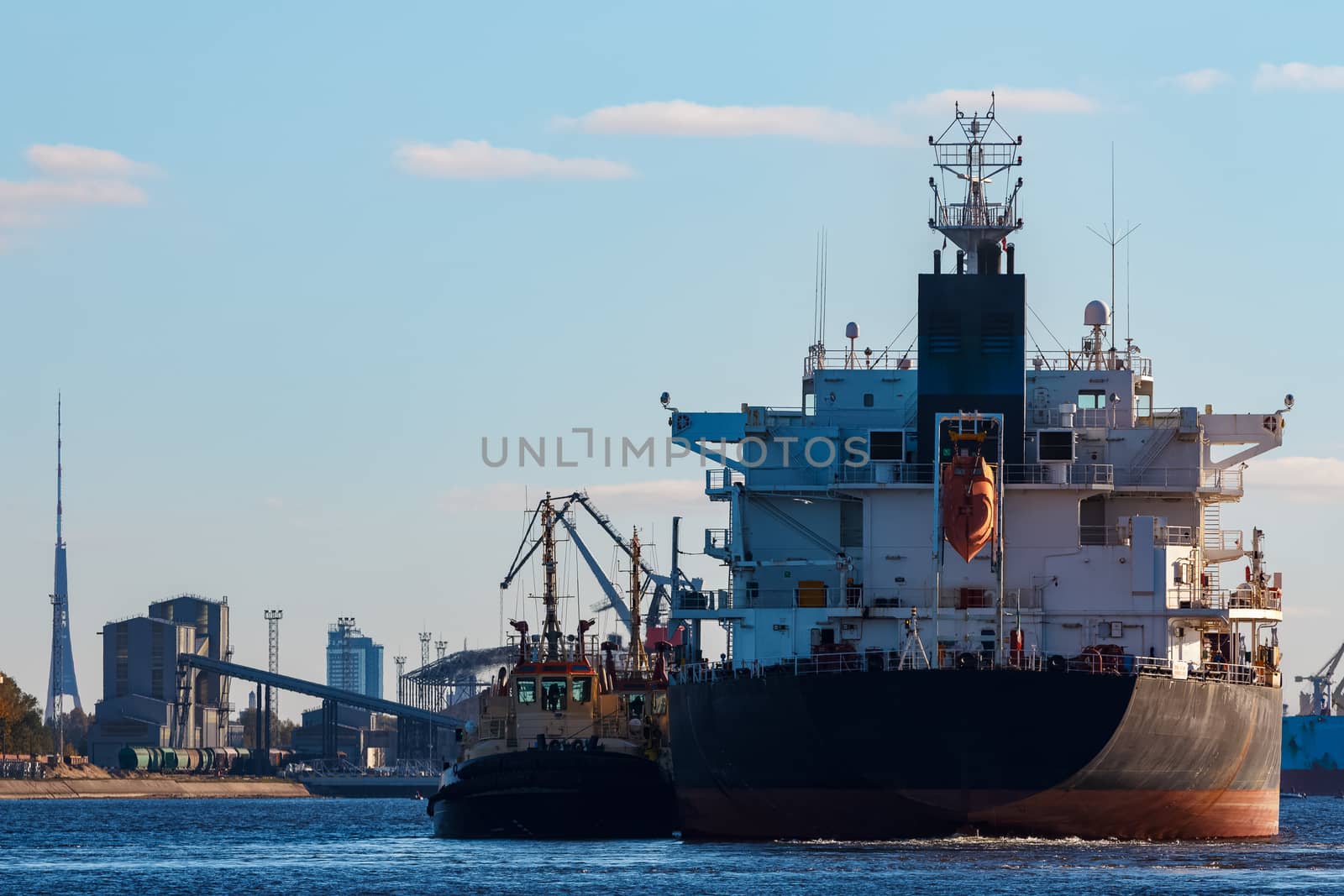 Black cargo ship entering the port of Riga, Europe