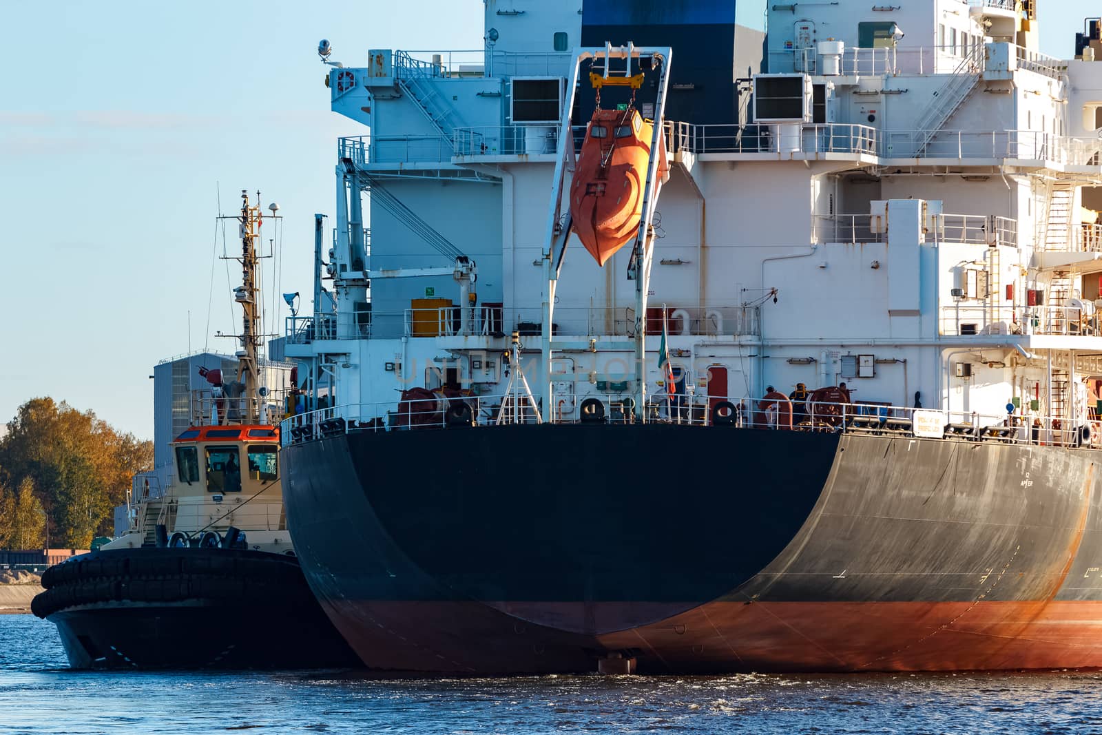 Black cargo ship entering the port of Riga, Europe