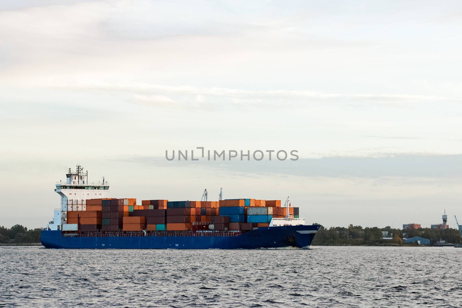 Blue container ship moving to Baltic sea. Riga, Latvia