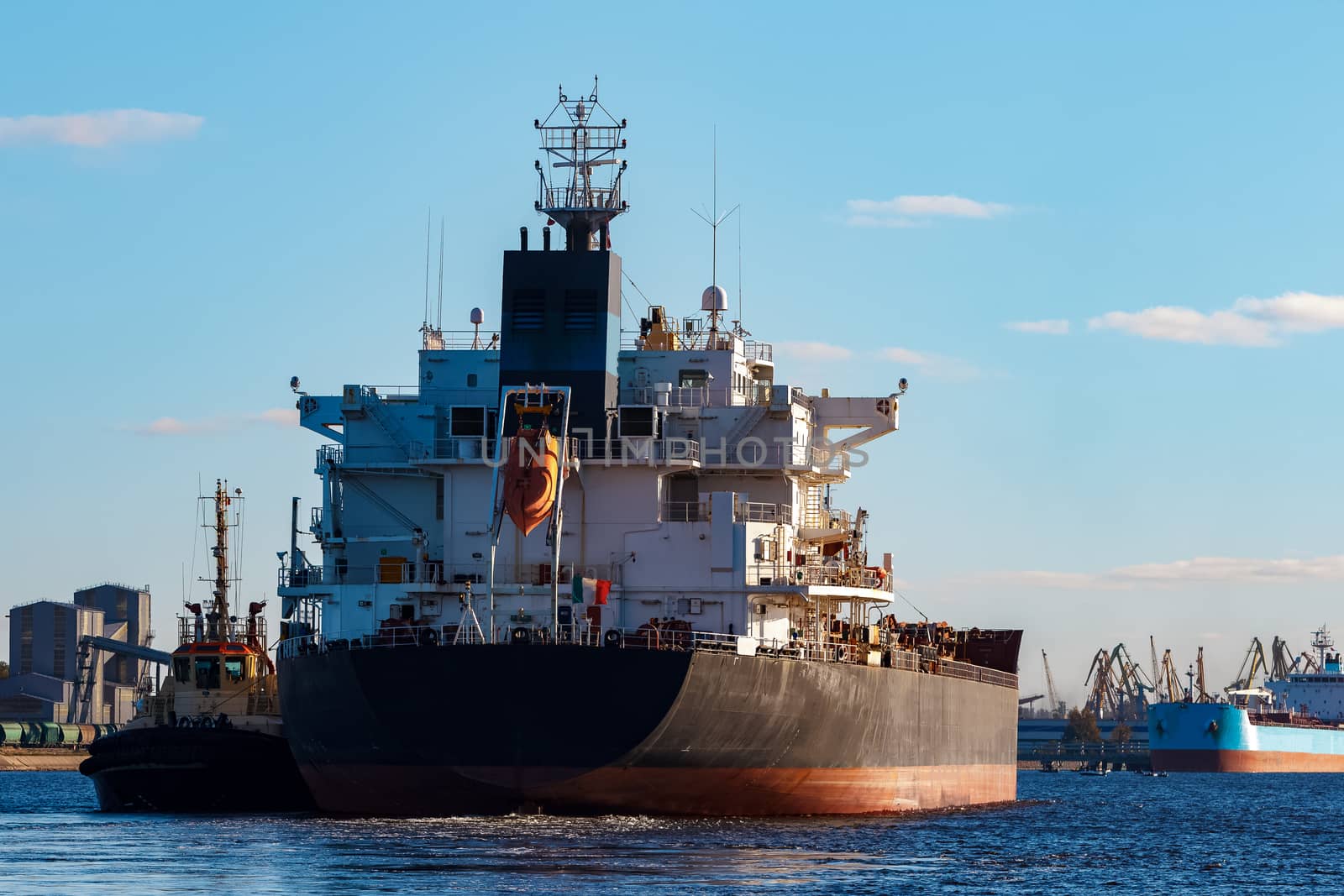 Black cargo ship entering the port of Riga, Europe