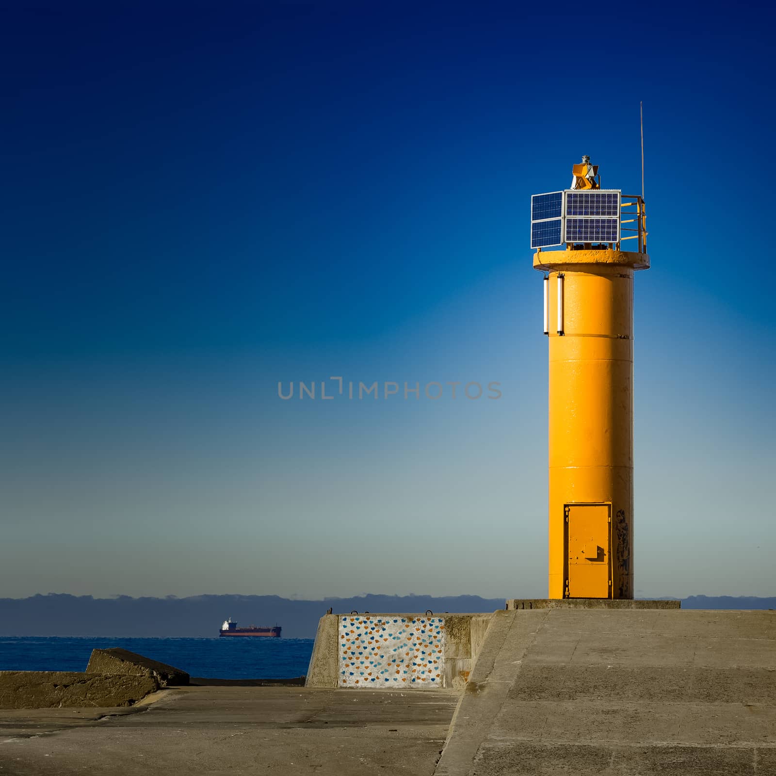 Yellow lighthouse on breakwater dam by sengnsp