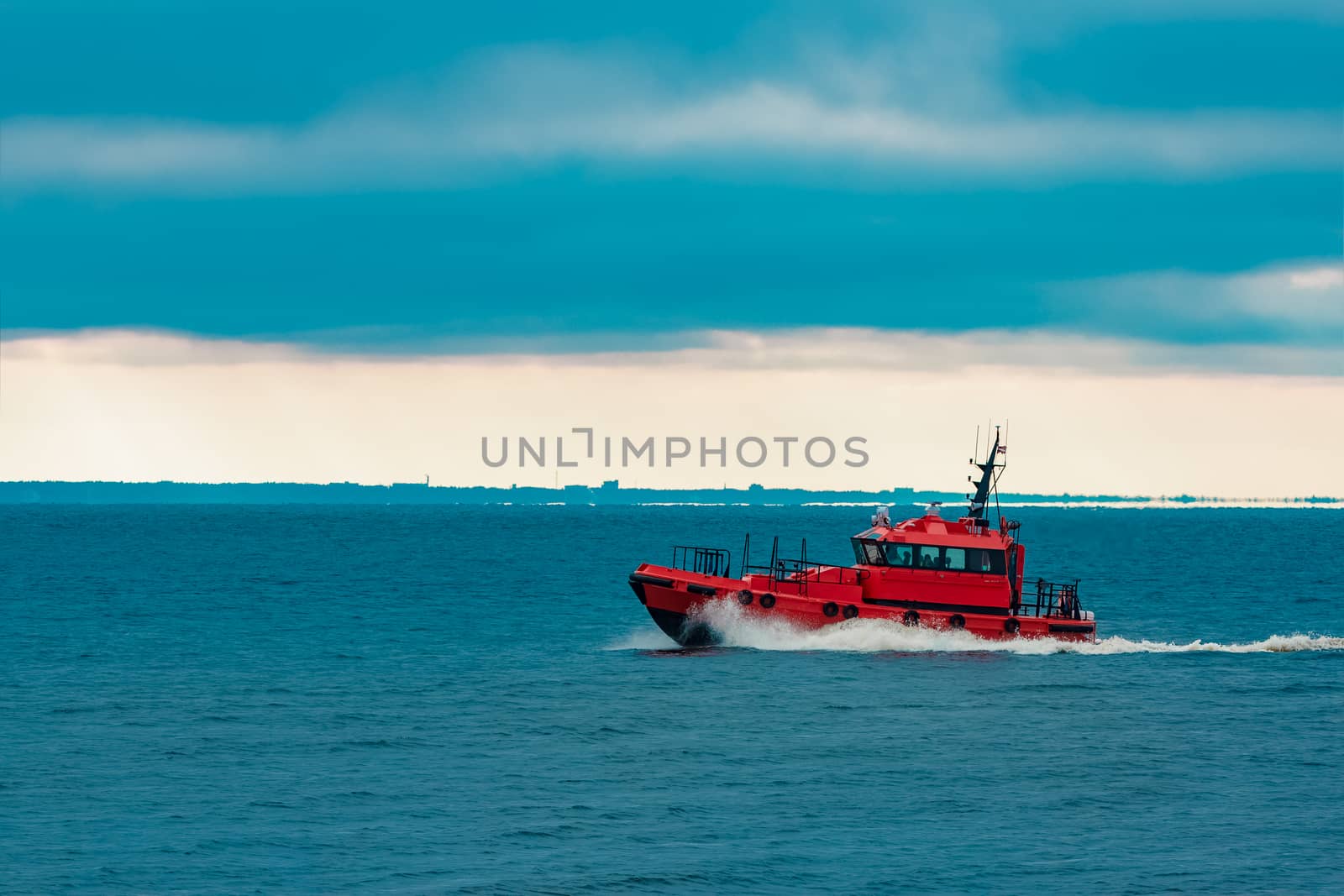 Red pilot ship moving at speed from Baltic sea