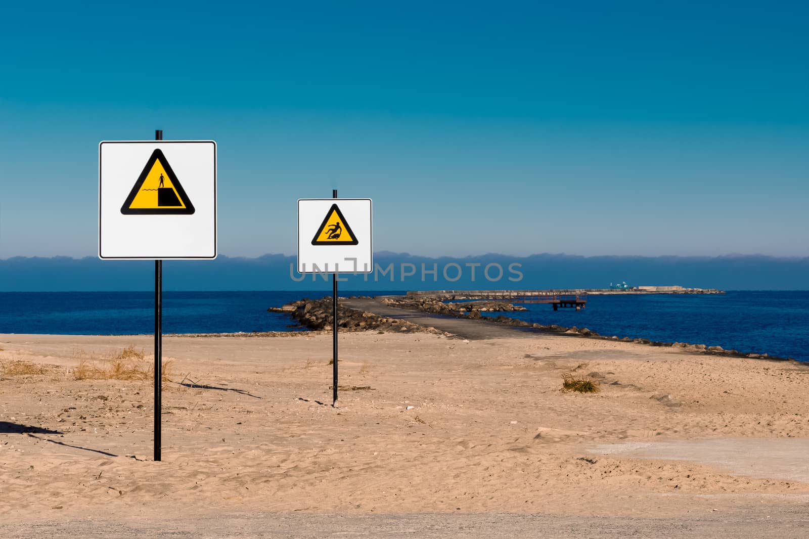 Yellow warning signs on summer beach, Riga