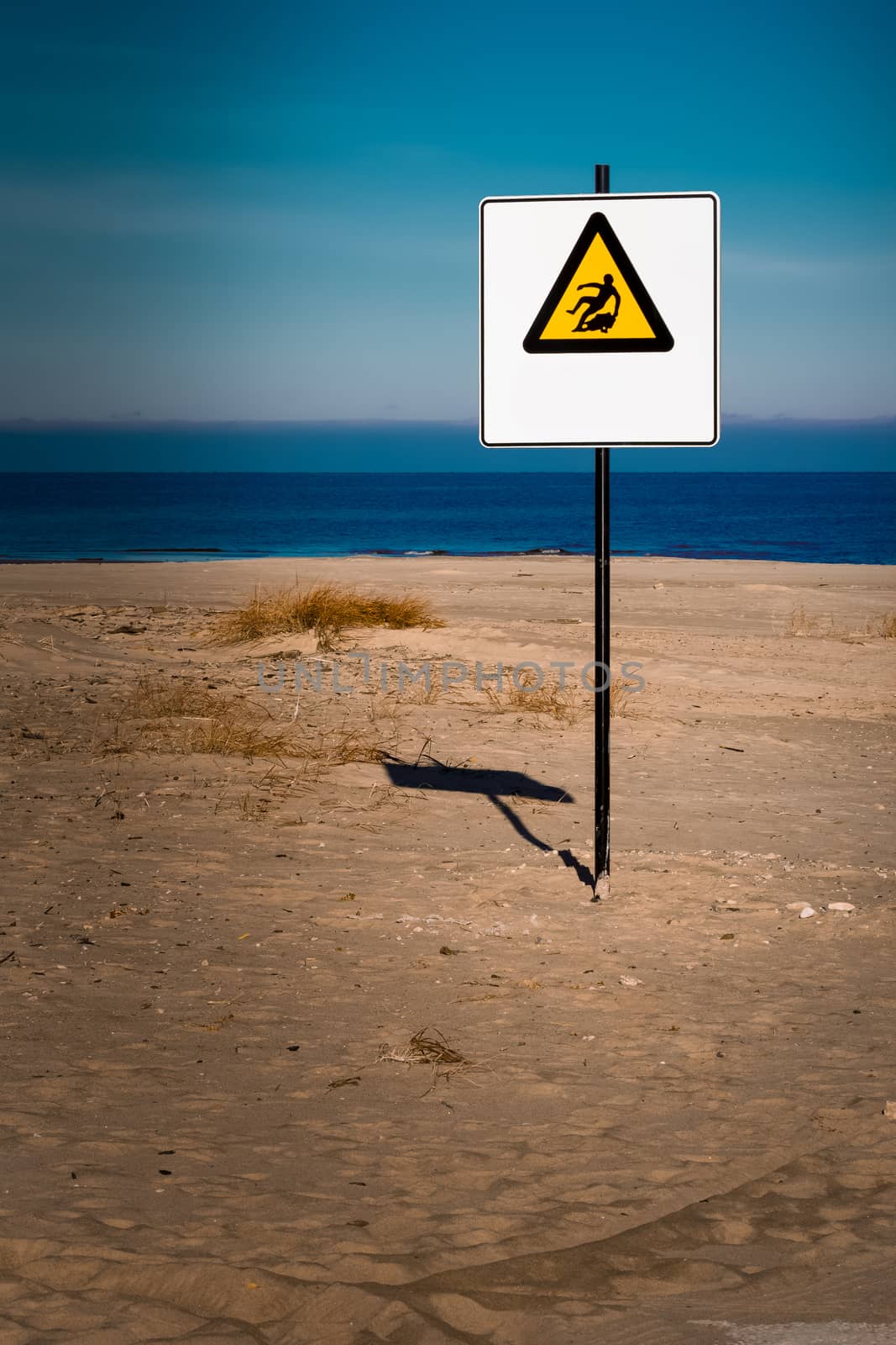 Yellow warning sign on summer beach, Riga