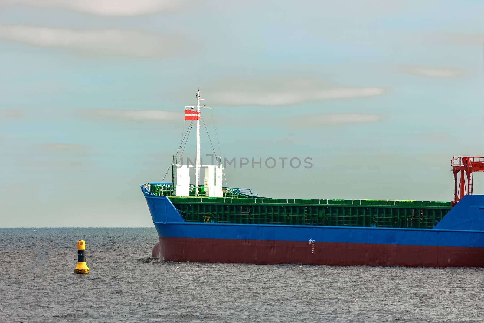 Blue cargo ship's bow leaving the port of Riga