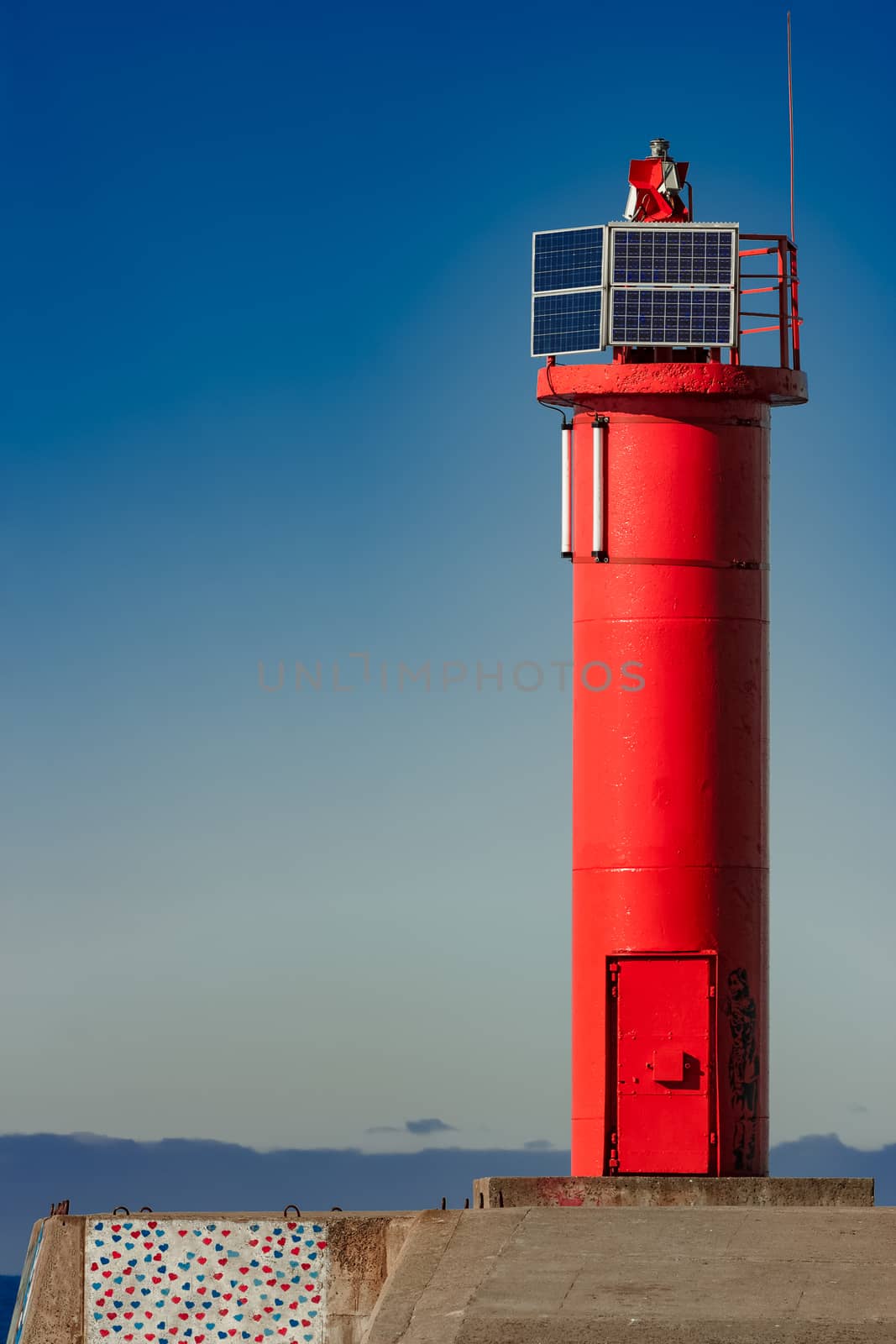 Red lighthouse on breakwater dam by sengnsp