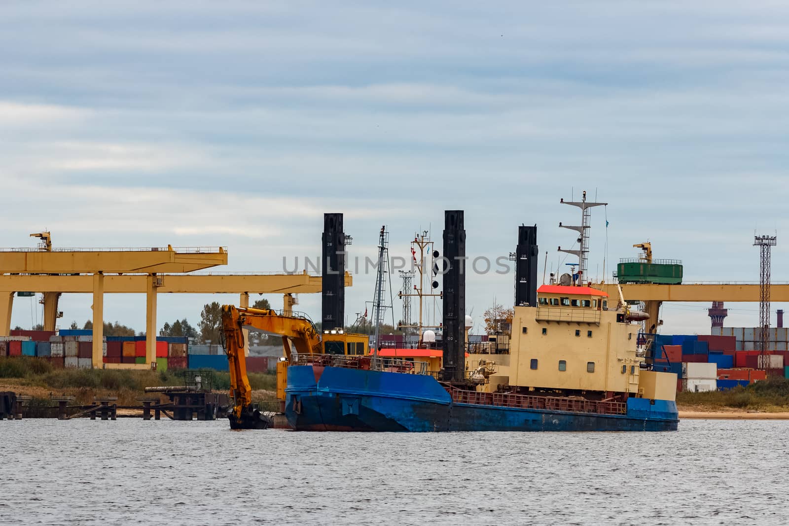 Blue cargo ship loading in the port of Riga, Europe