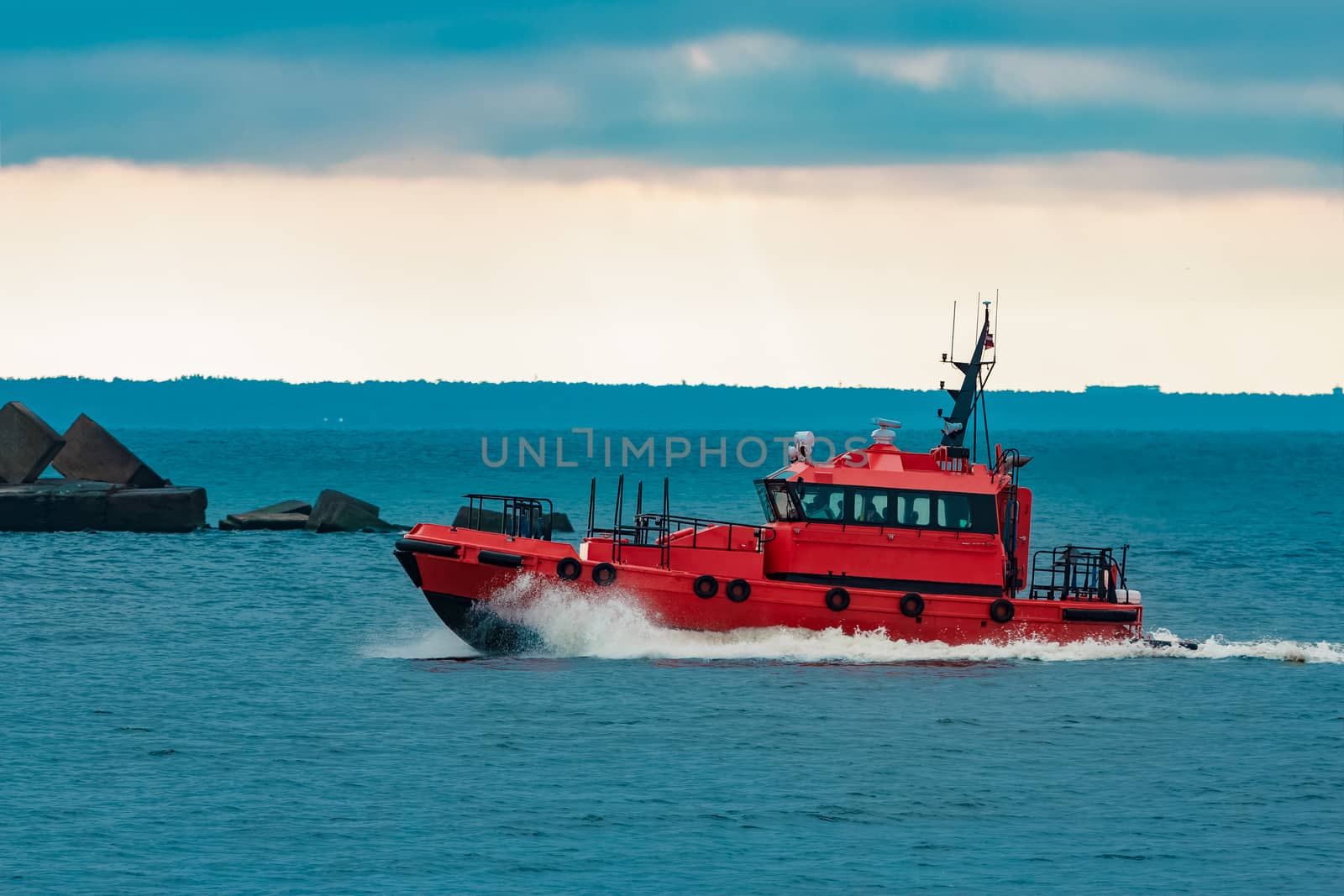 Red pilot ship moving fast from Baltic sea