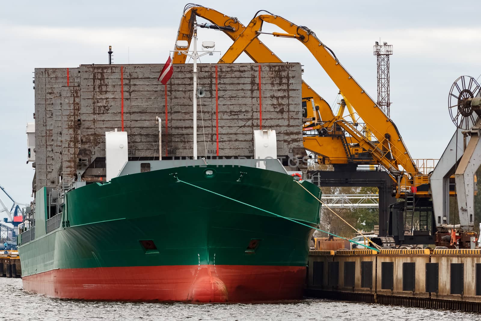 Green cargo ship loading in the port of Riga, Europe