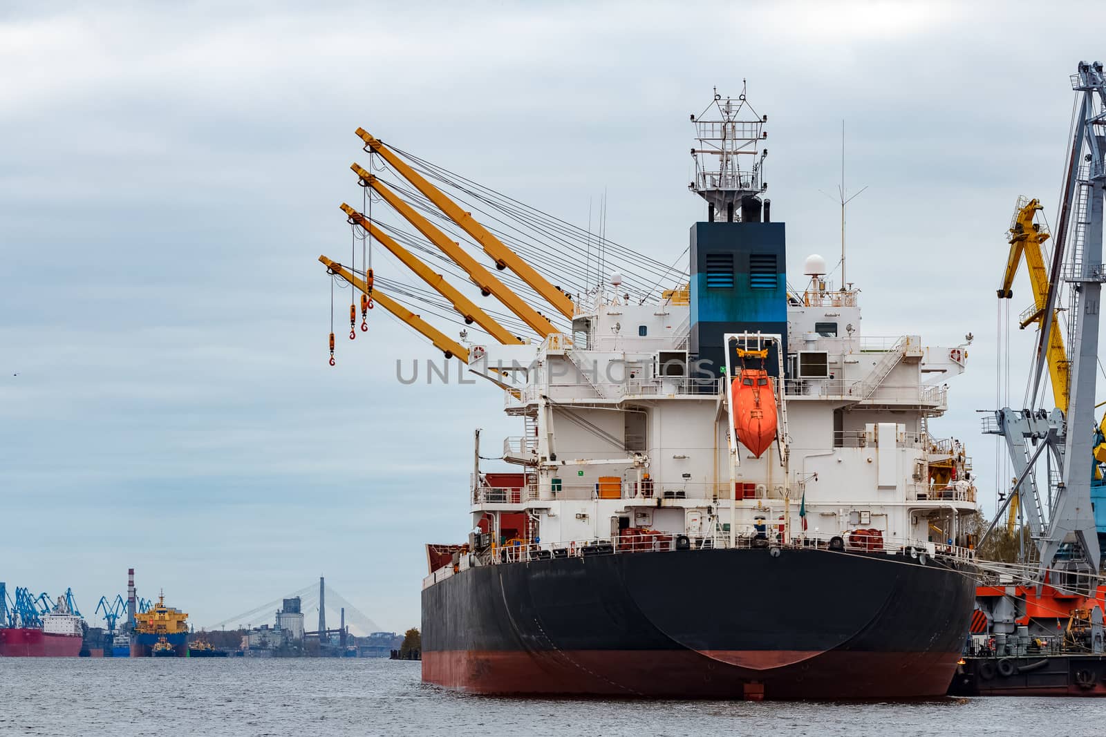 Black cargo ship loading in the port of Riga, Europe