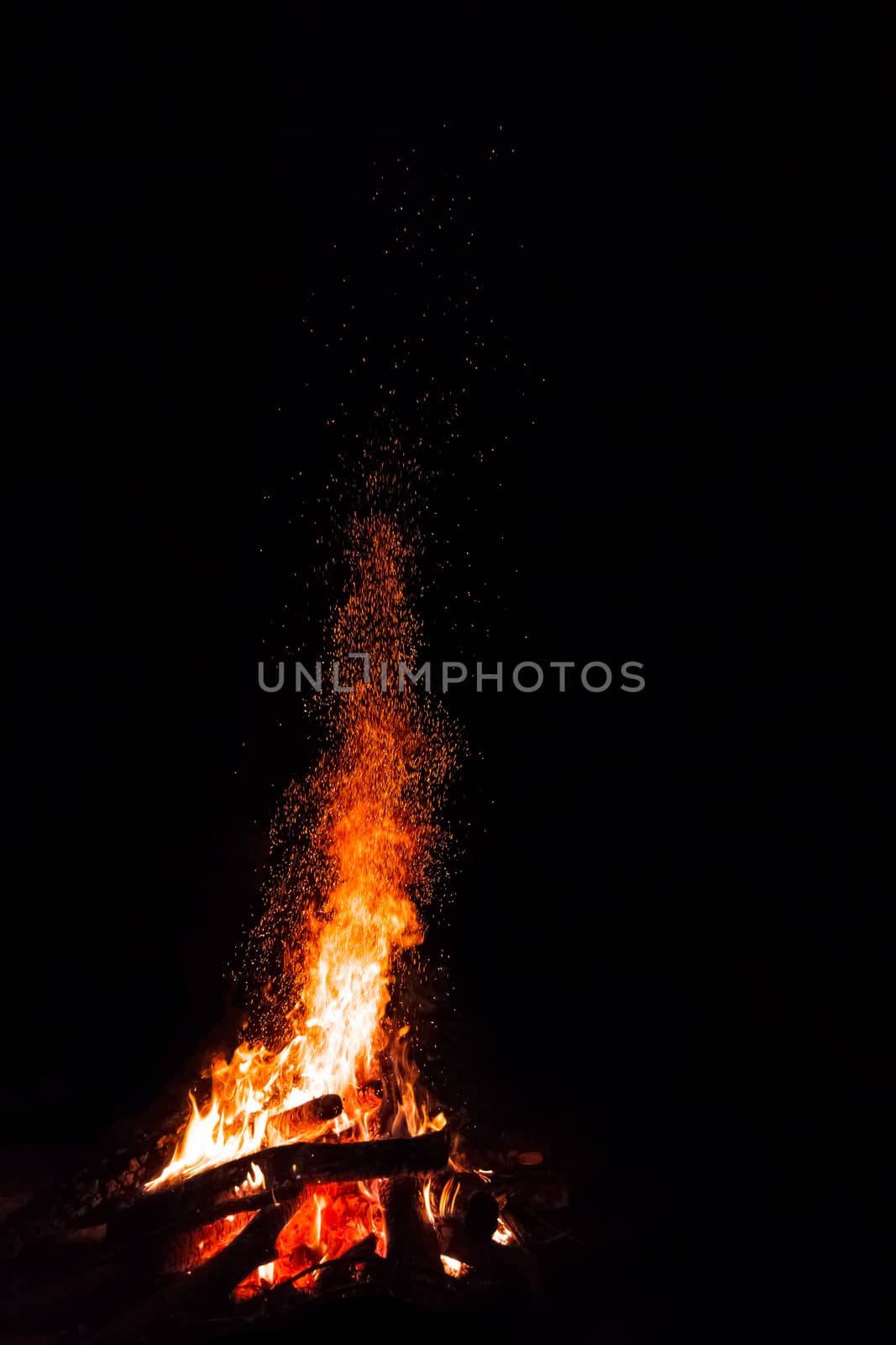 Campfire with flying sparks isolated on black background