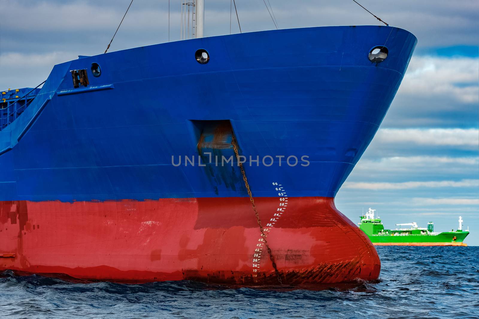 Blue cargo ship moored in still Baltic sea water