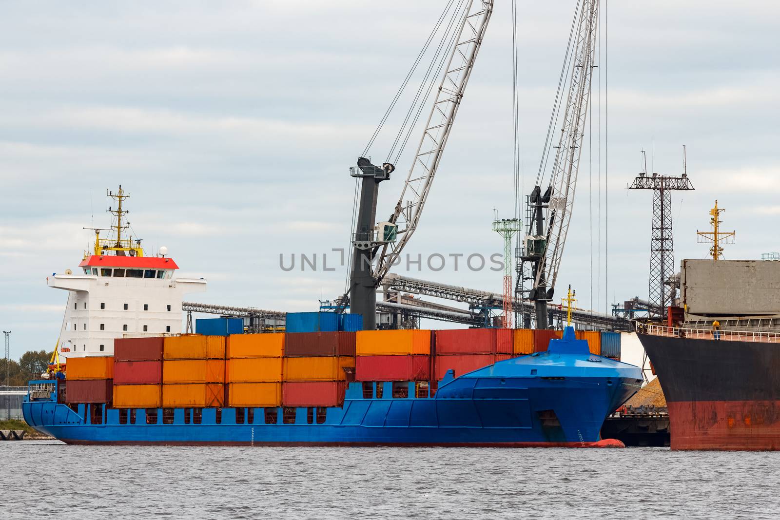 Blue container ship loading in cargo port of Europe