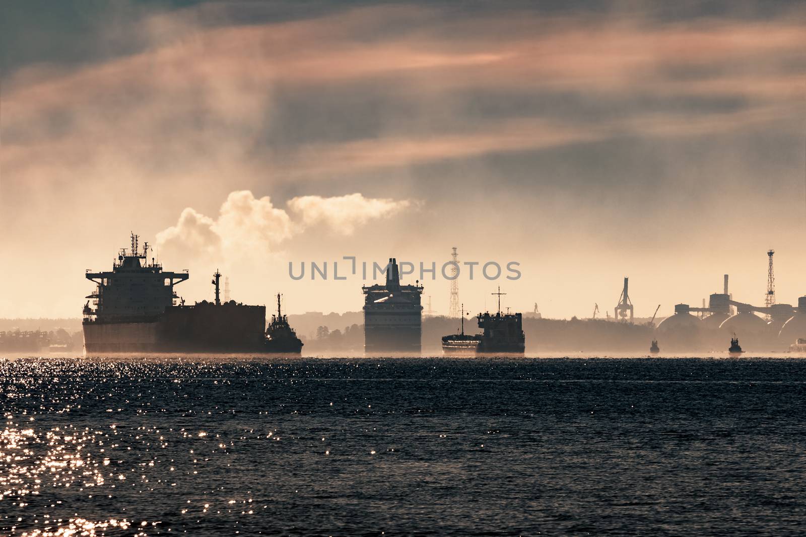 Cargo ship silhouette entering a port of Riga at the morning