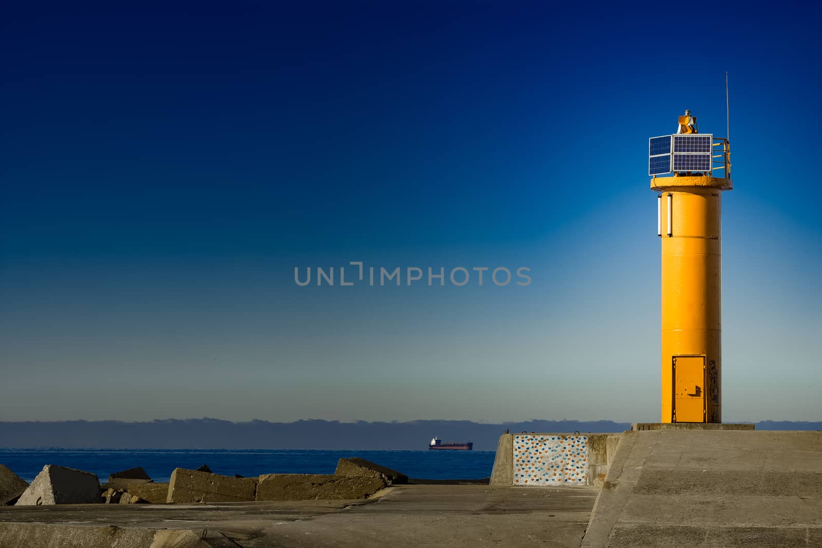 Yellow lighthouse on breakwater dam by sengnsp