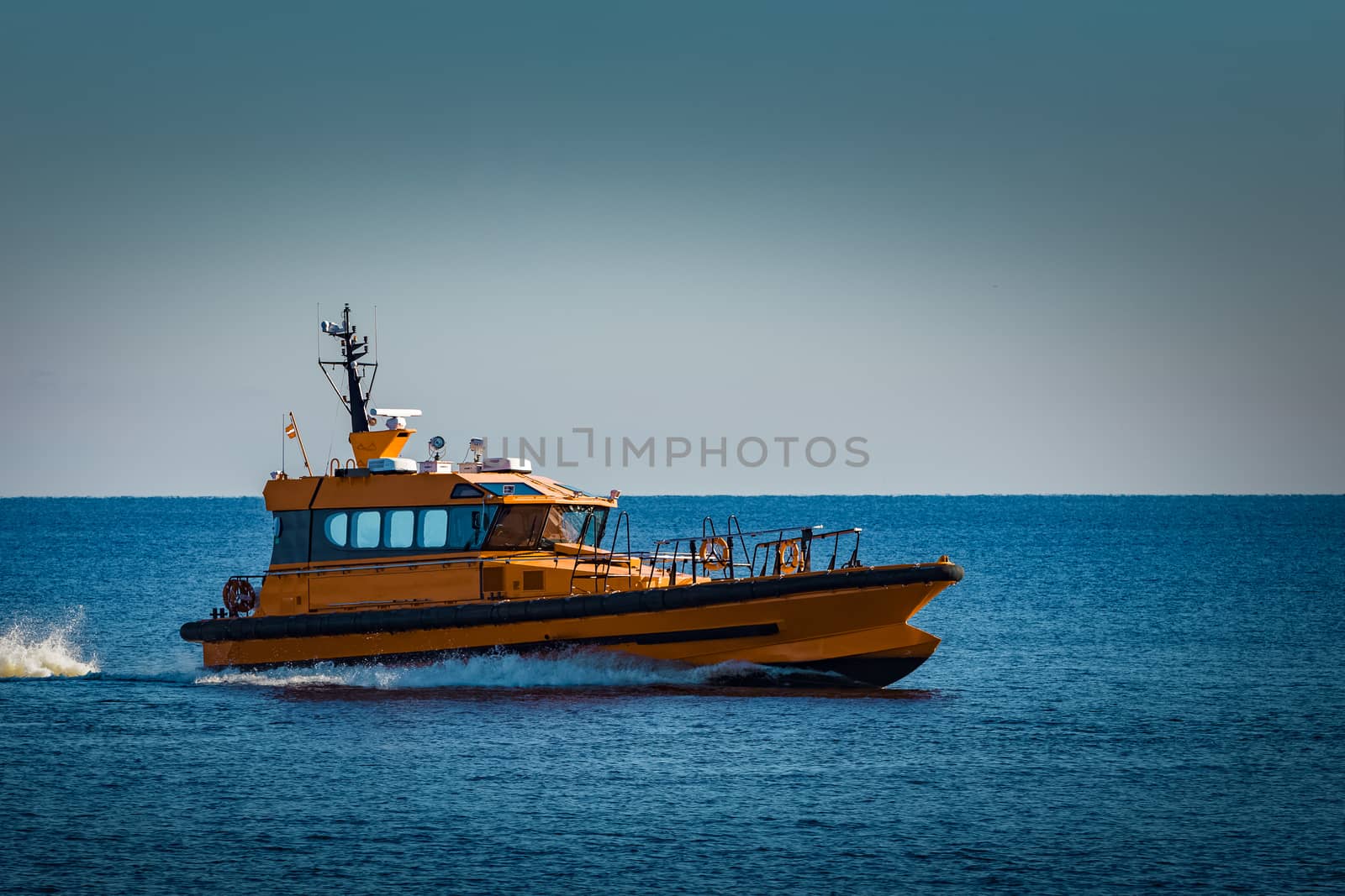 Yellow pilot ship moving at speed from the Baltic sea