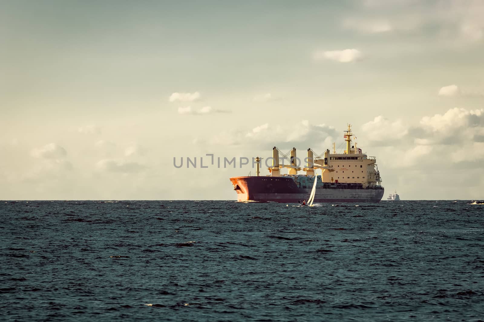 Red cargo ship moving entering the port of Riga