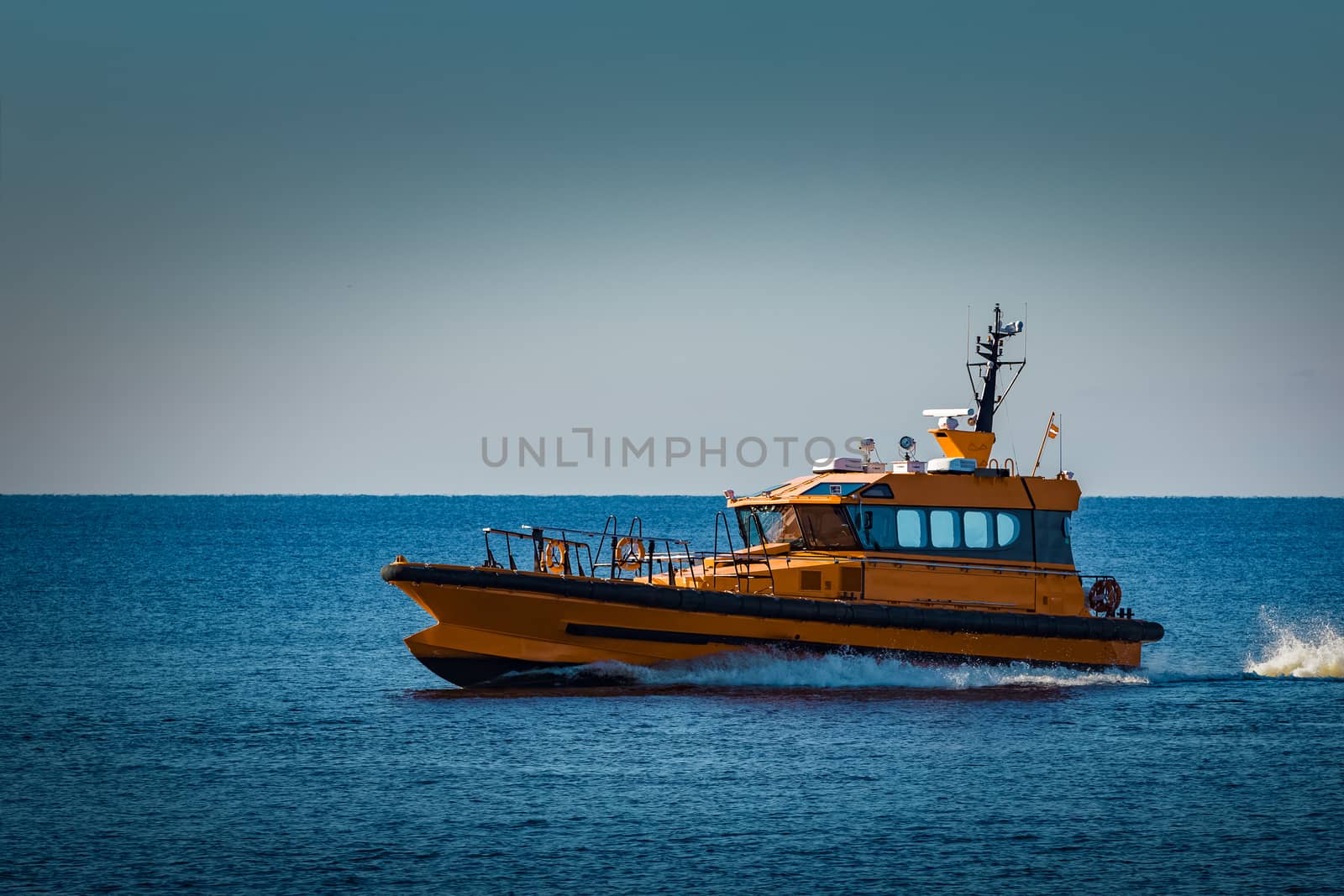 Yellow pilot ship moving at speed from the Baltic sea