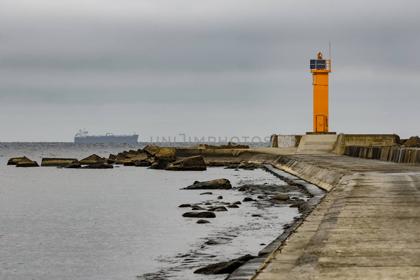 Breakwater dam with yellow lighthouse by sengnsp