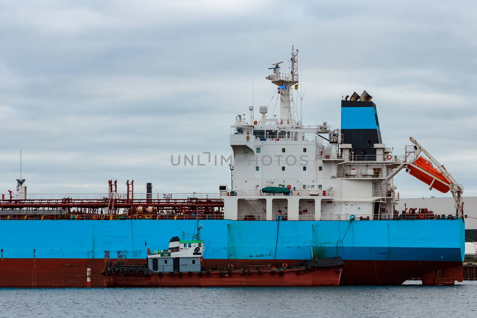 Blue cargo ship loading in the port of Riga, Europe