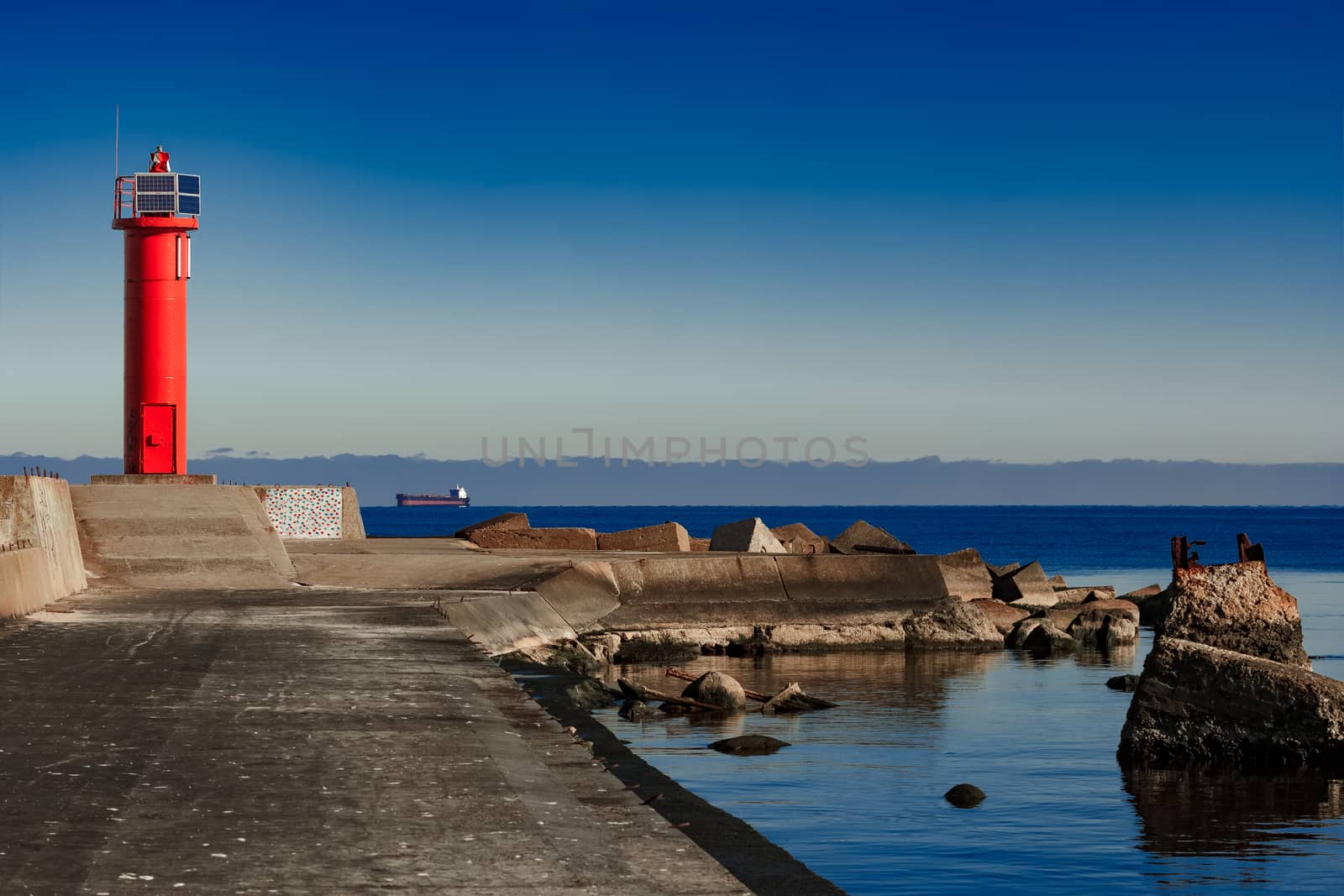 Red lighthouse on breakwater dam by sengnsp