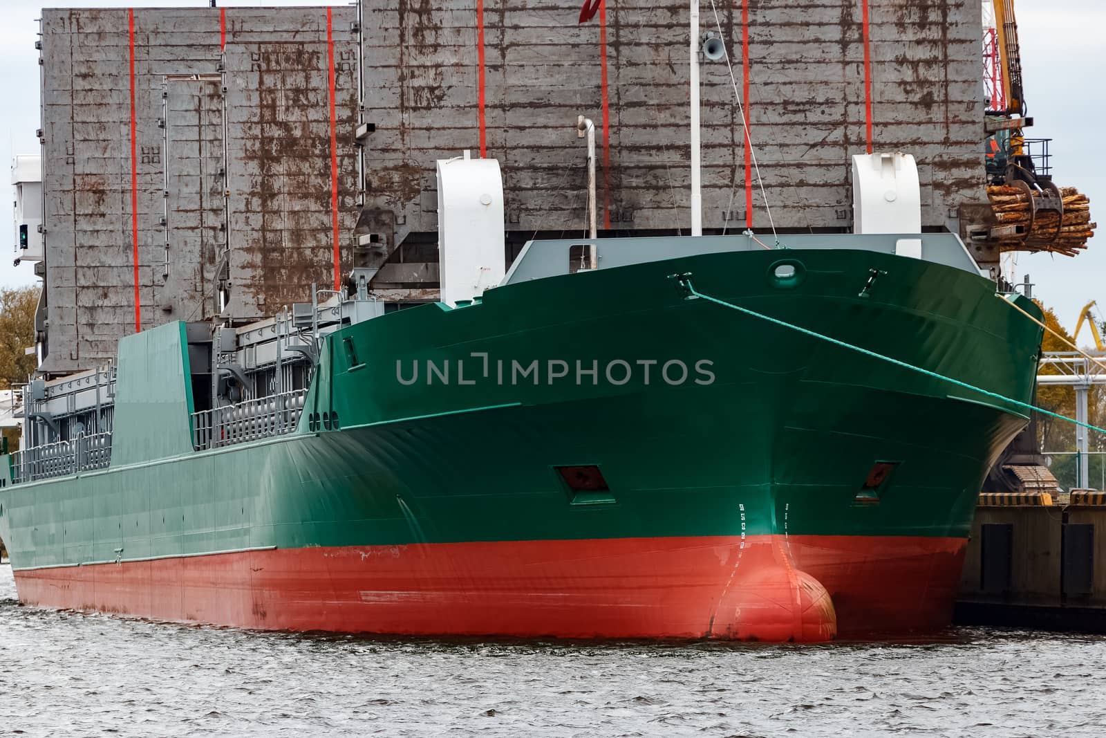 Green cargo ship loading in the port of Riga, Europe