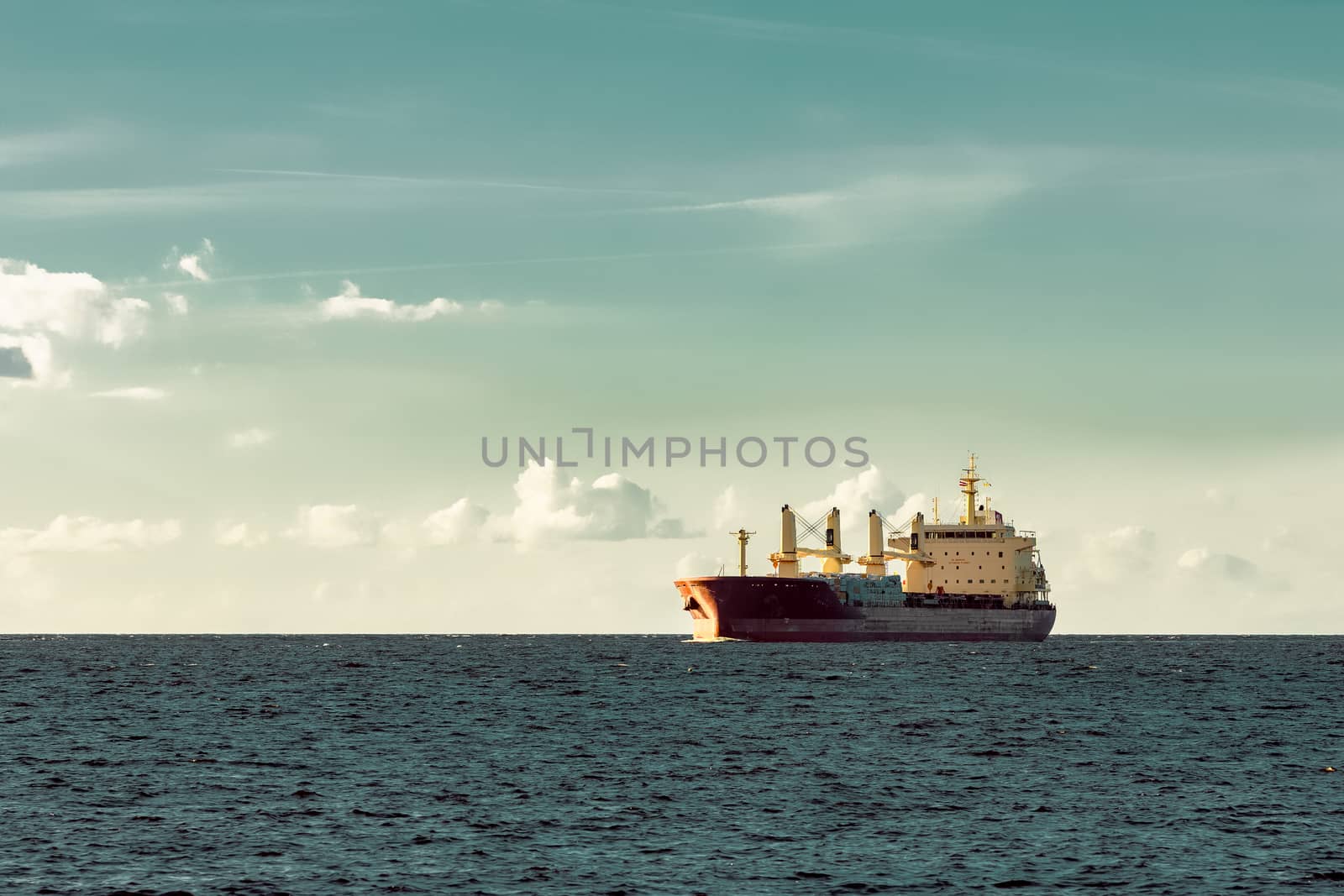 Red cargo ship sailing in open sea