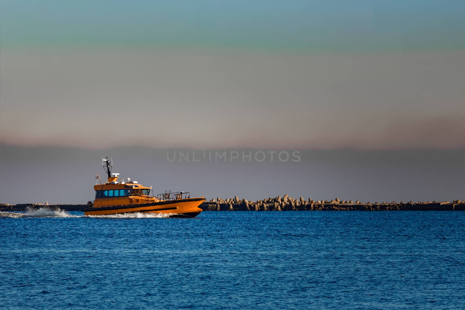 Orange pilot ship sailing from the Baltic sea in Latvia