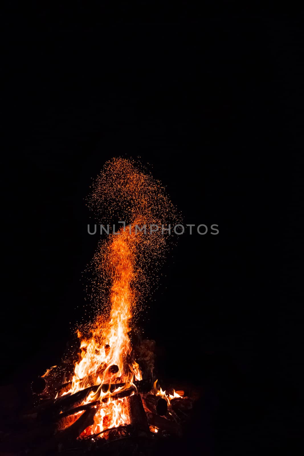 Campfire with flying sparks isolated on black background