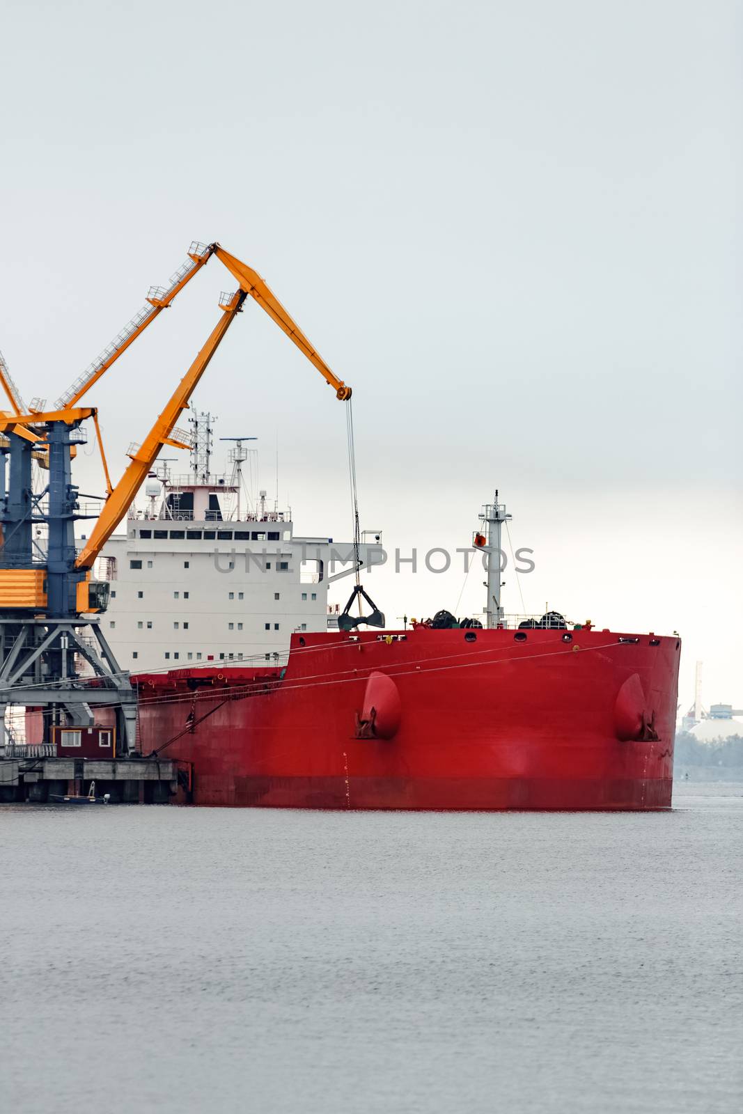 Large red cargo ship loading by sengnsp