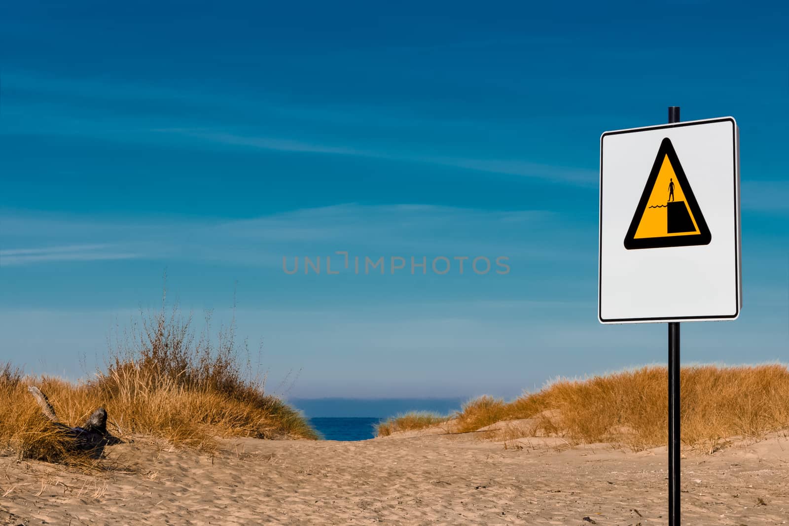 Yellow warning sign on summer beach, Riga